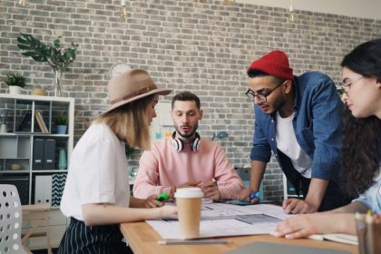 Jovens trabalham juntos em uma sessão de brainstorming em um escritório moderno.