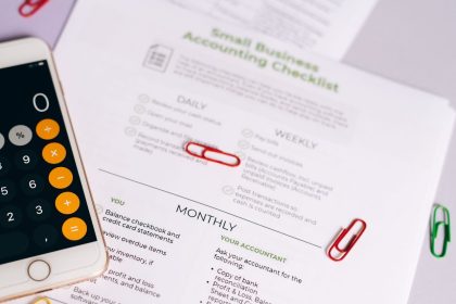 Checklist e calculadora sobre uma mesa, representando a organização das obrigações contábeis de um pequeno negócio